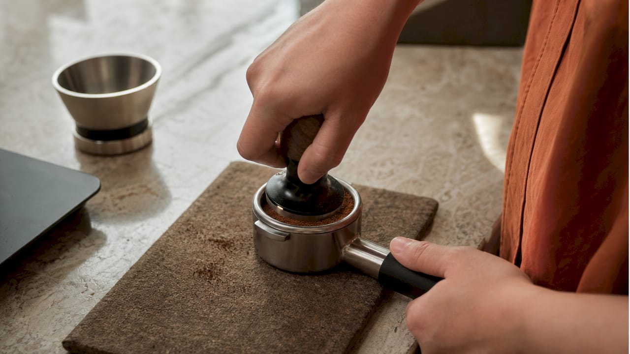Close-up of tamper pressing coffee grounds