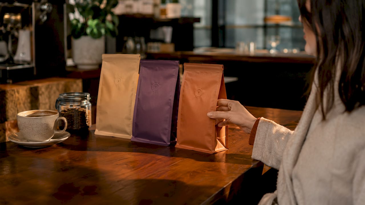 Consumer choosing from three coffee bags overhead view