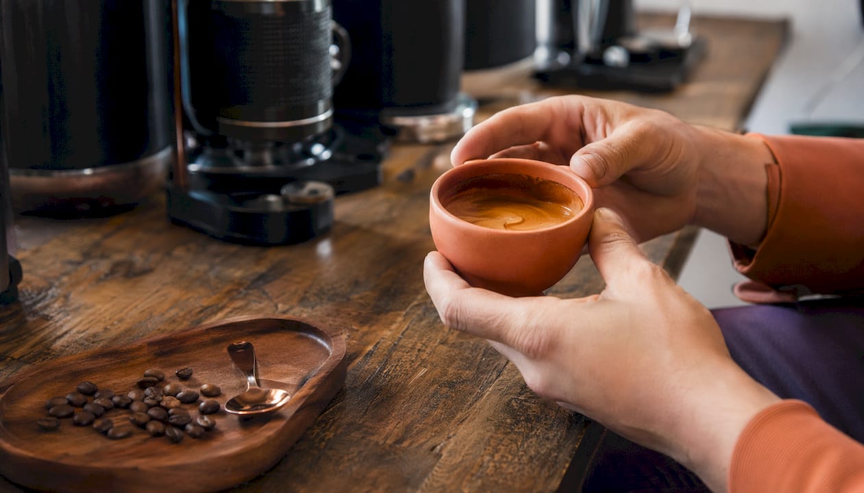Close-up of hands swirling coffee with sensory tools