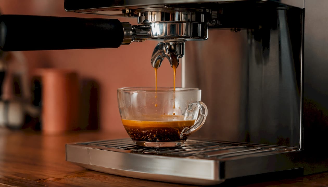 Espresso machine extracting coffee with visible crema bubbles