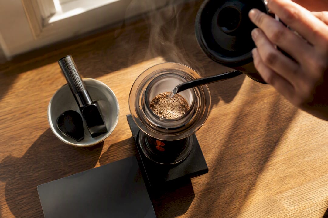 Pouring water over light roast grounds in AeroPress pre-infusion
