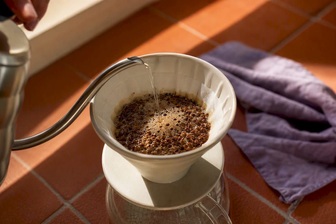 Slow water pour over coarse coffee grounds