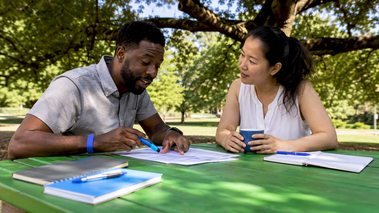 Two professionals negotiating contract terms across table