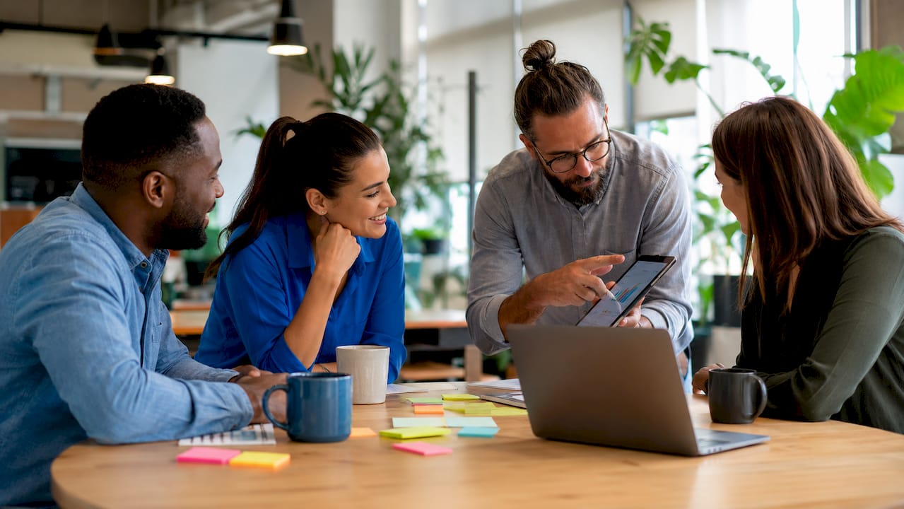 Business team discussing software options around table