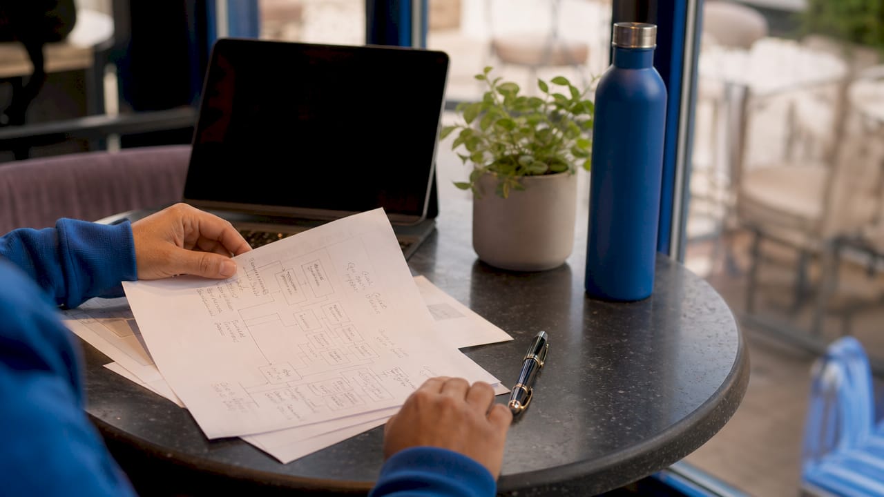 Hands reviewing app project scope papers