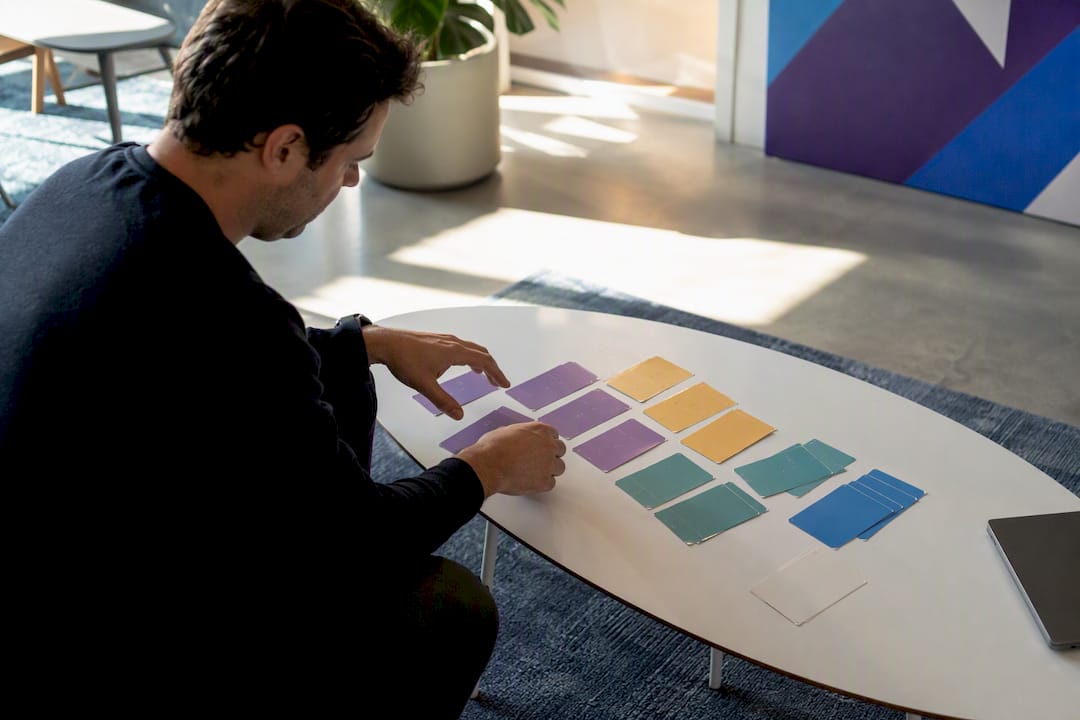 Hands arranging subscription pricing tokens
