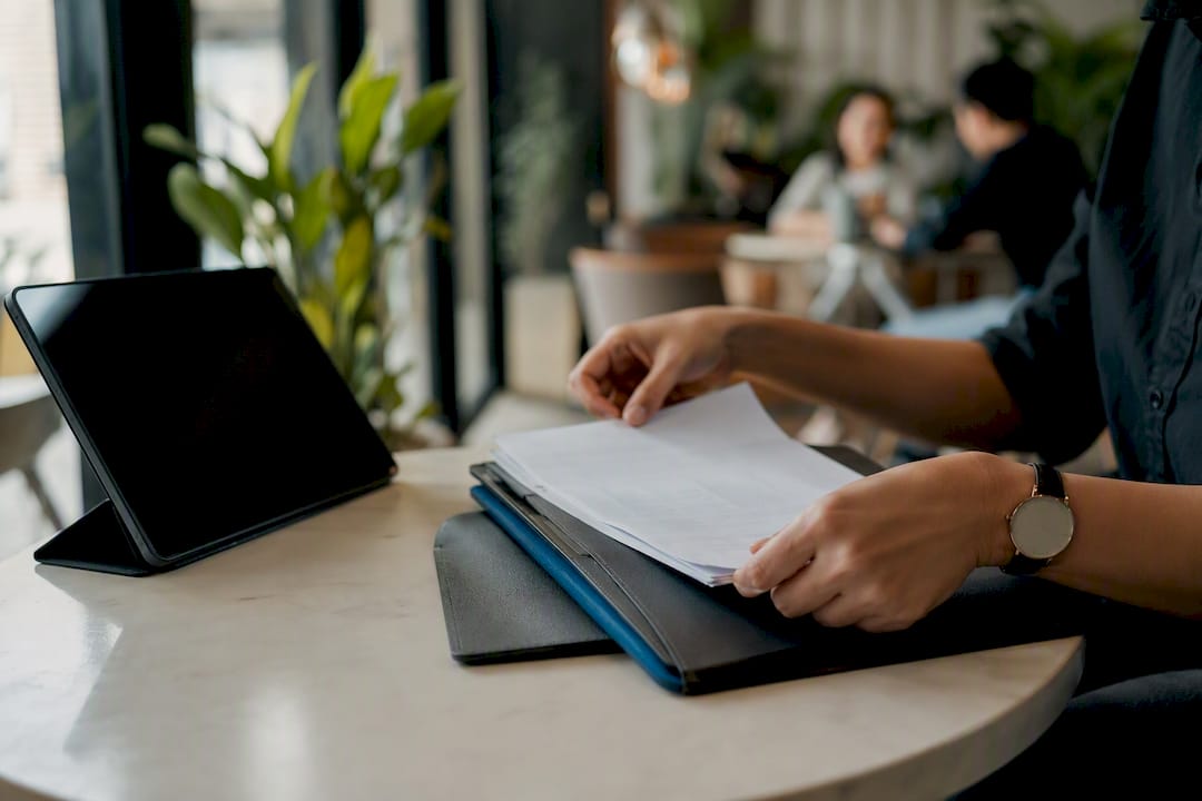 Hands setting aside spreadsheet papers on desk