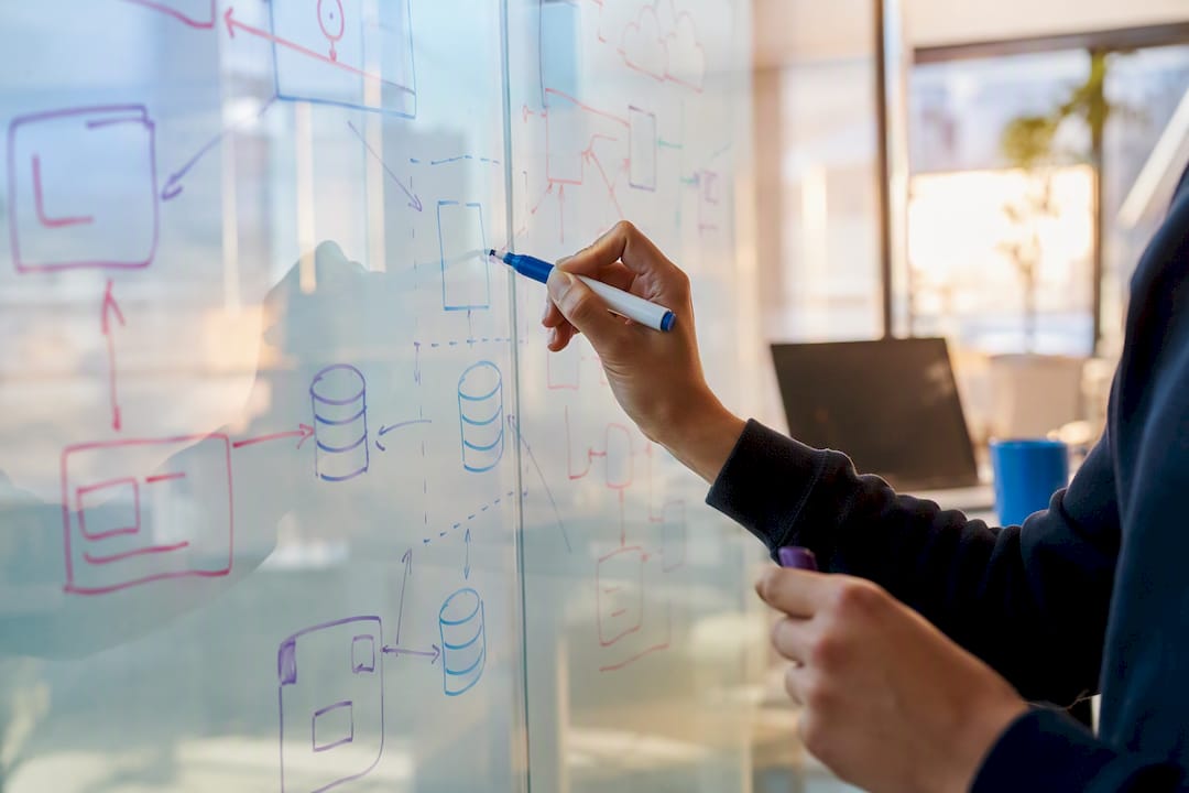 Hands drawing system architecture on glass wall