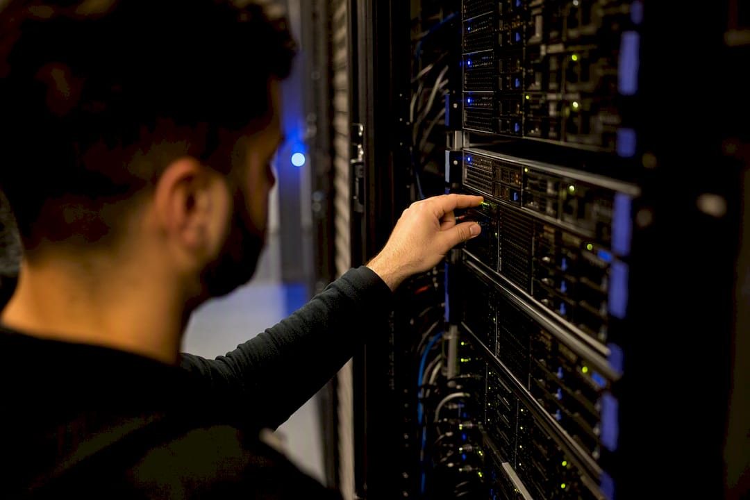 Technician inspecting server status lights in data center