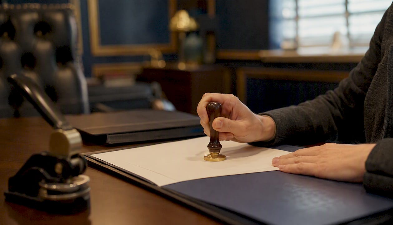 Hands applying notary seal in apostille service office