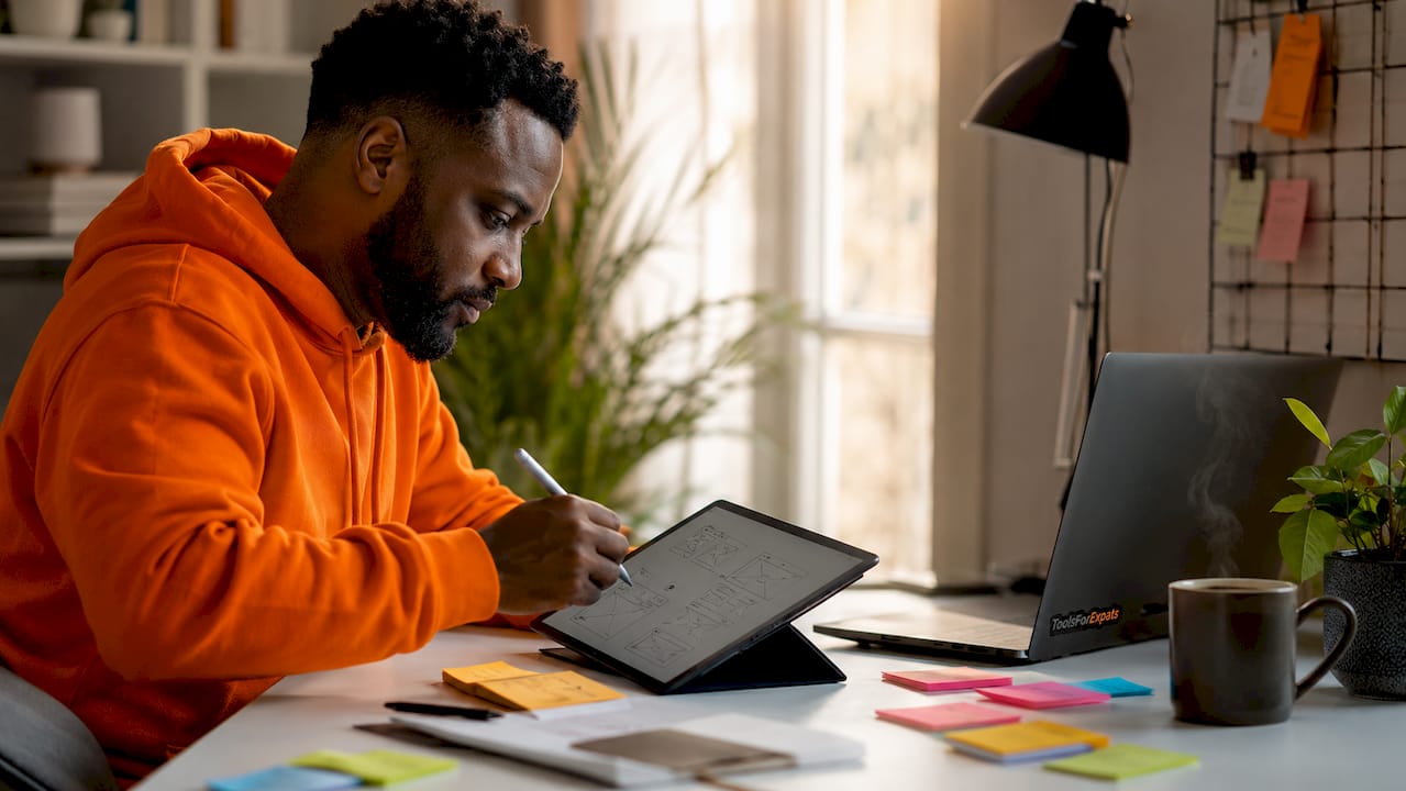 Man designing digital product wireframes on tablet