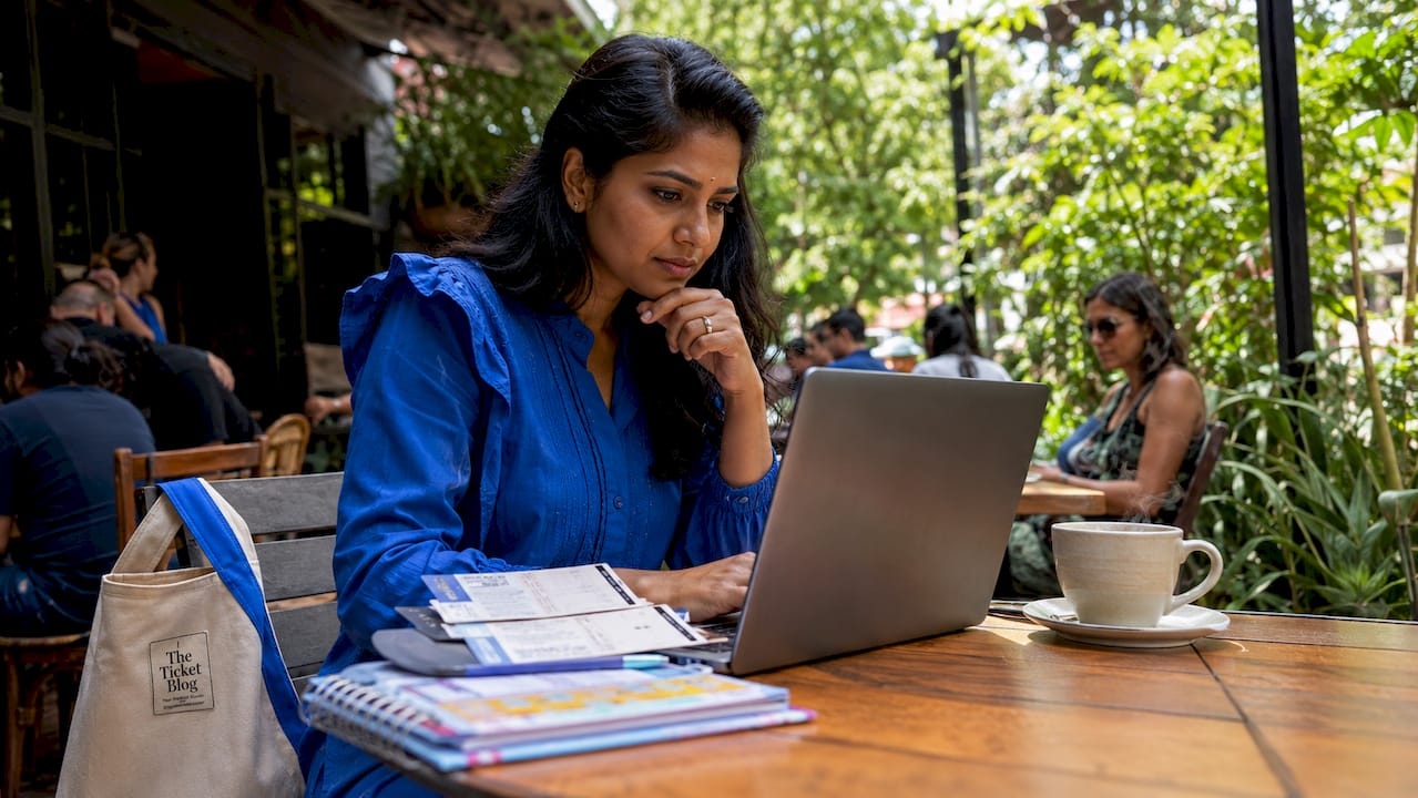 Woman reviewing online ticketing platform brochures at home