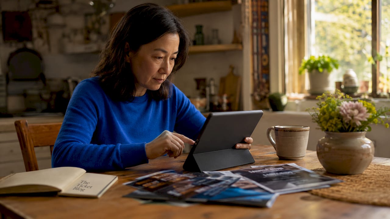 Woman browsing tickets at home desk