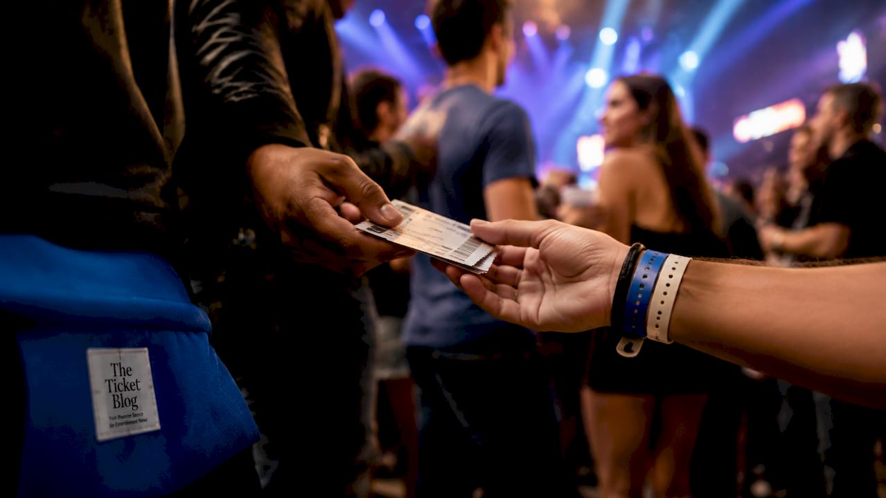 Hands exchanging concert tickets at festival gate