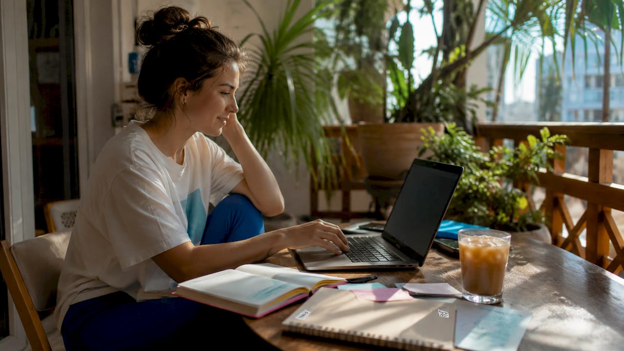 Woman browsing concert ticket discounts at kitchen table