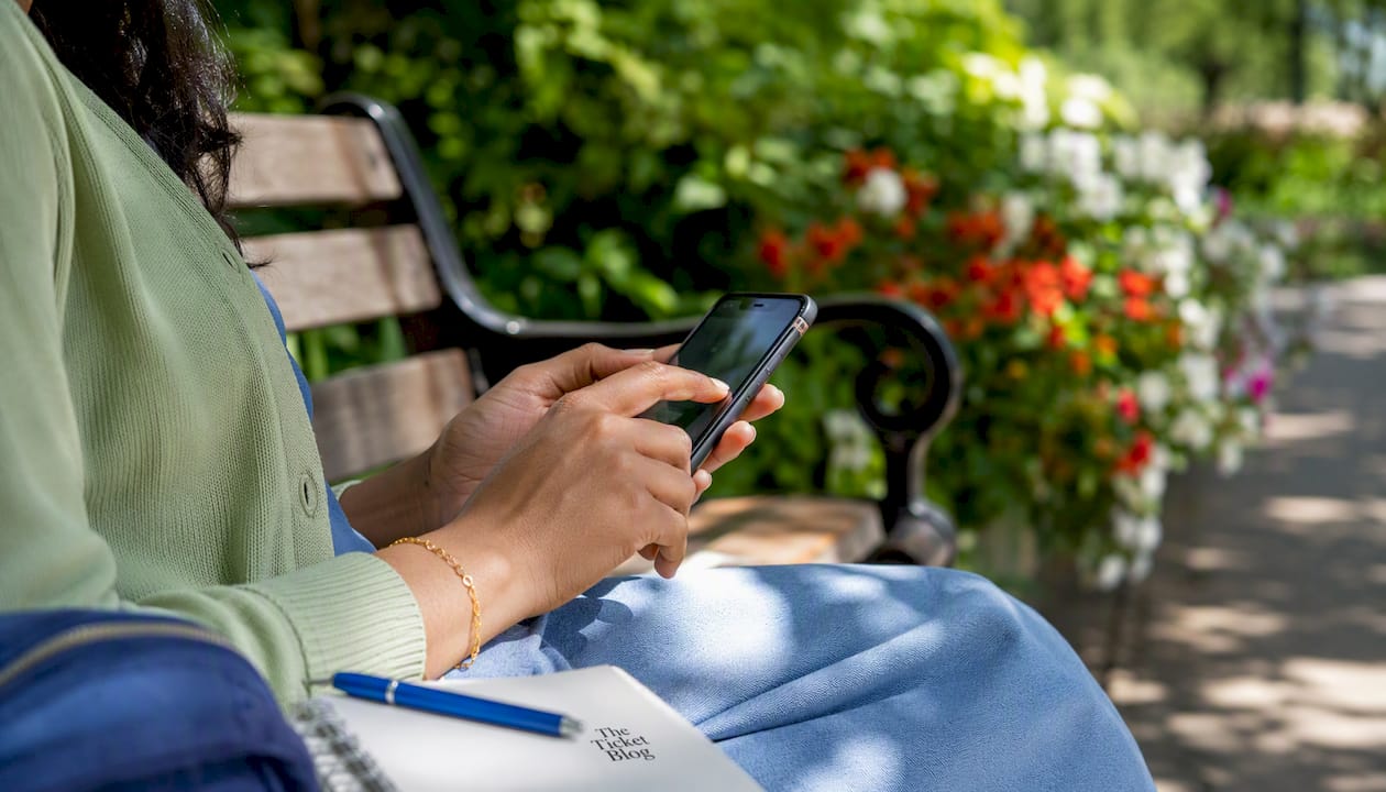 Hands using smartphone to check ticket prices