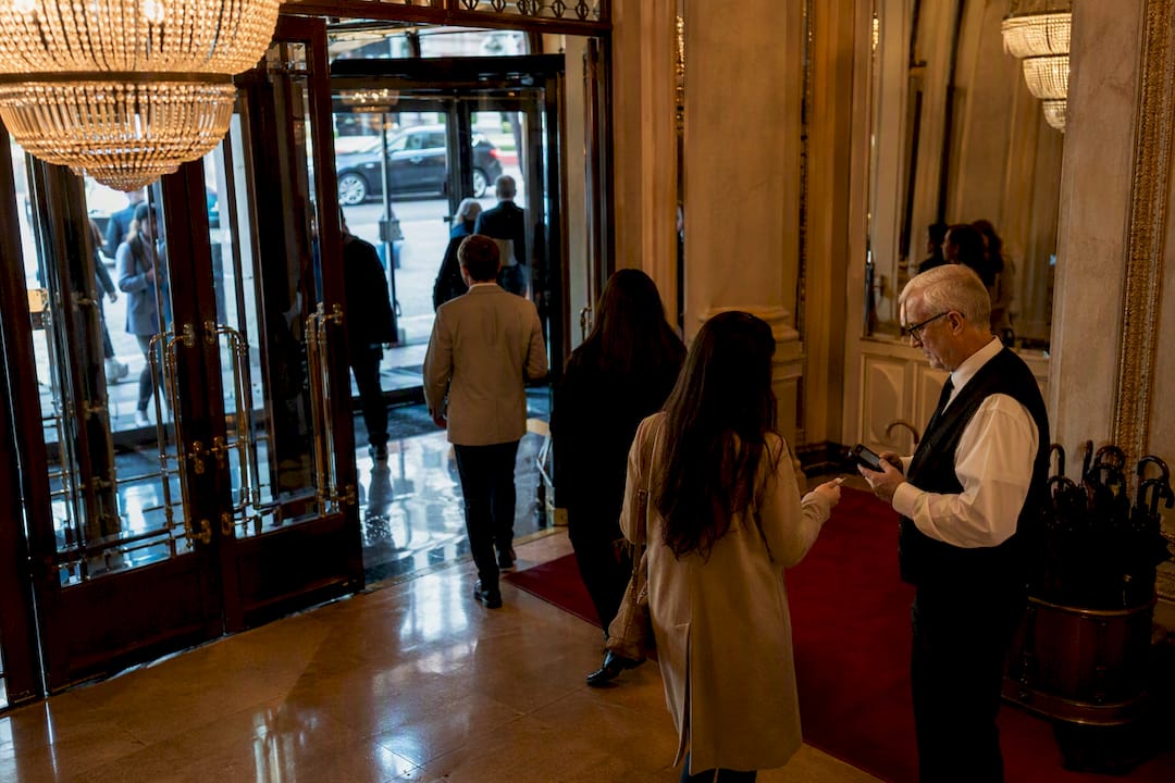 Audience entering theater through wooden doors