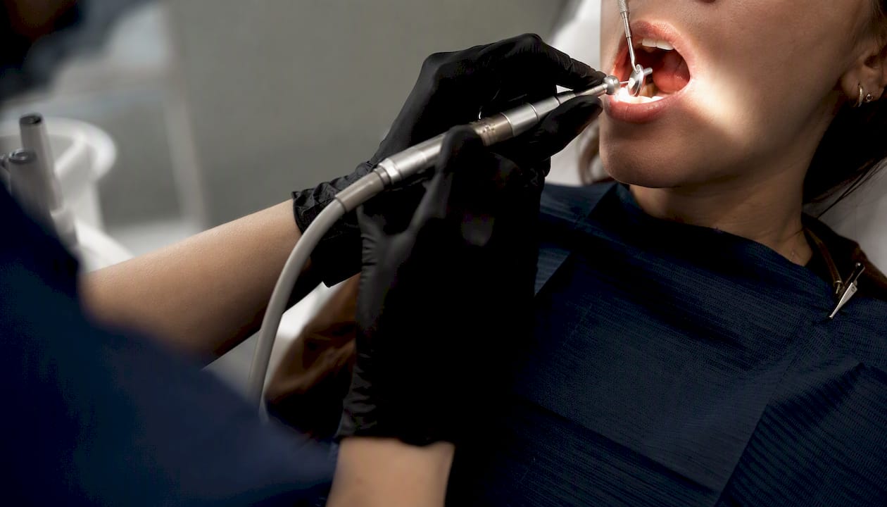 Hygienist cleaning teeth with scaling tools