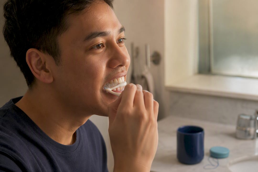 Gentle brushing along gums with toothbrush