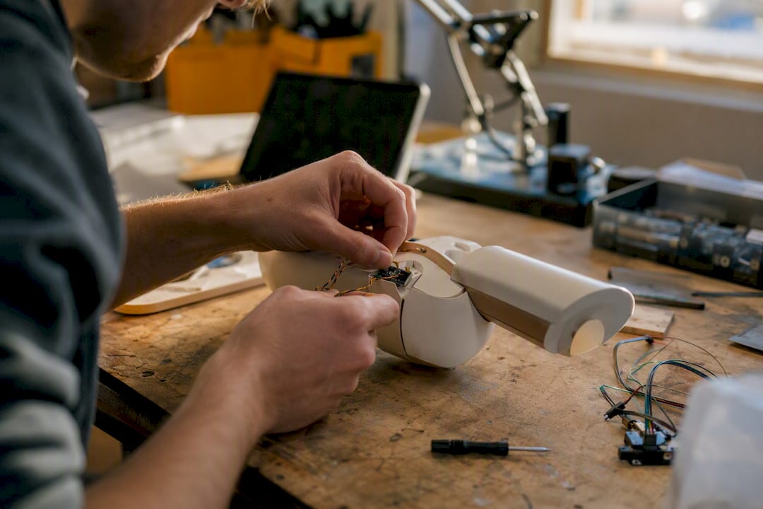 Hands connecting sensor on prototype in lab
