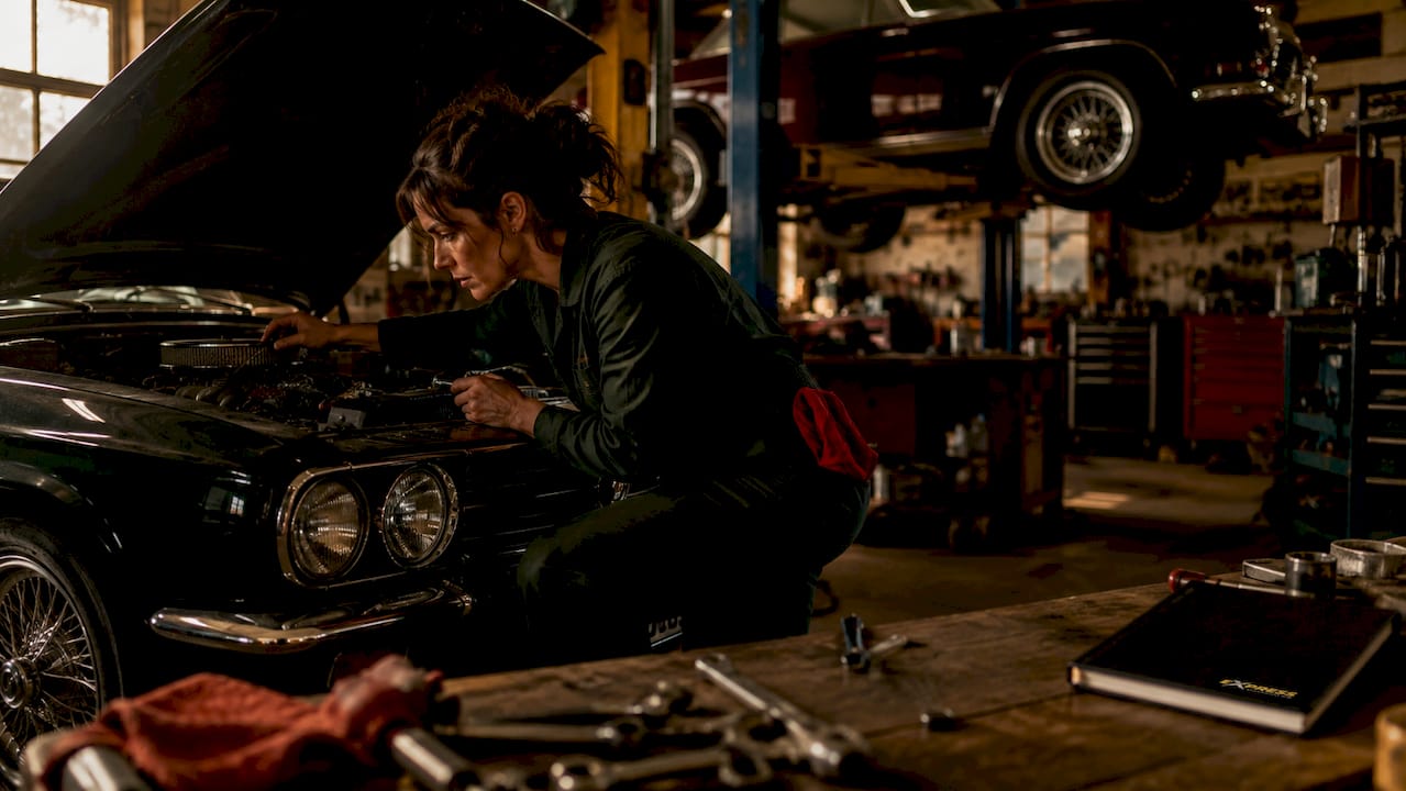 Mechanic inspecting car engine in repair shop