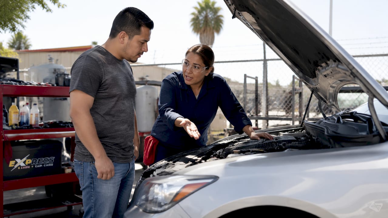 Mechanic explaining repairs to car owner in garage