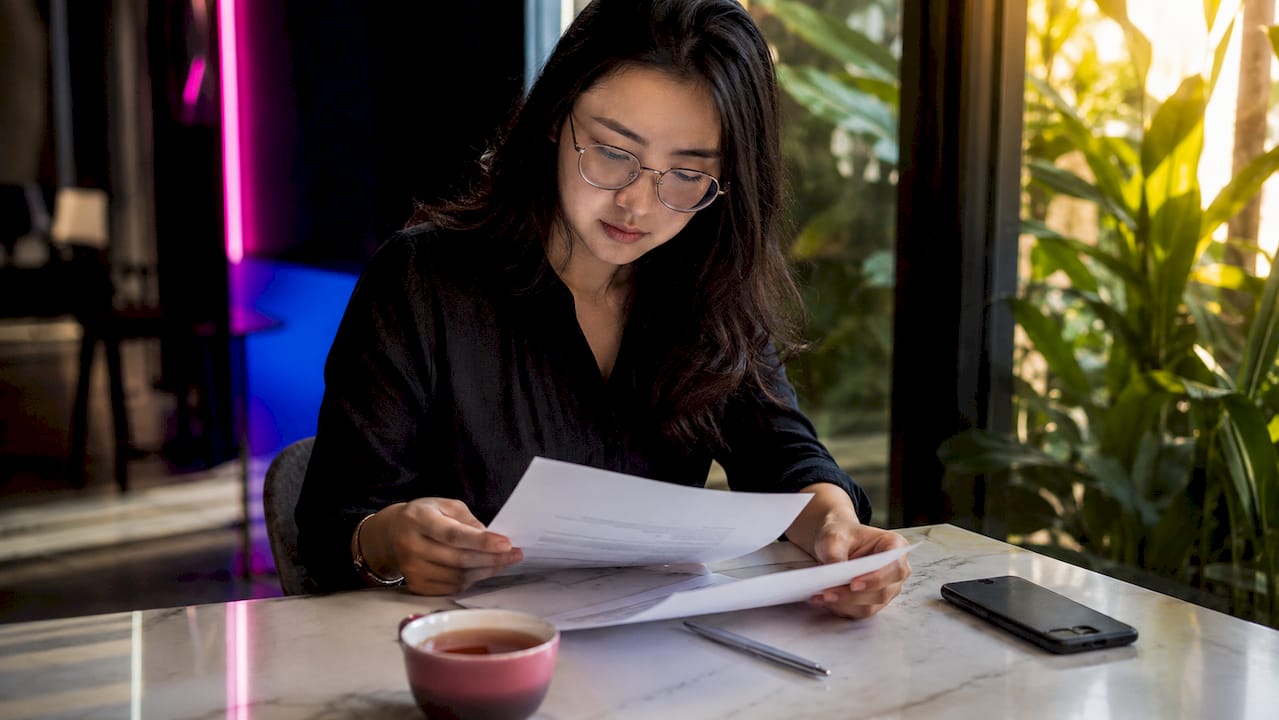 Une femme en train d'examiner un contrat de niveau de service (SLA) à son bureau