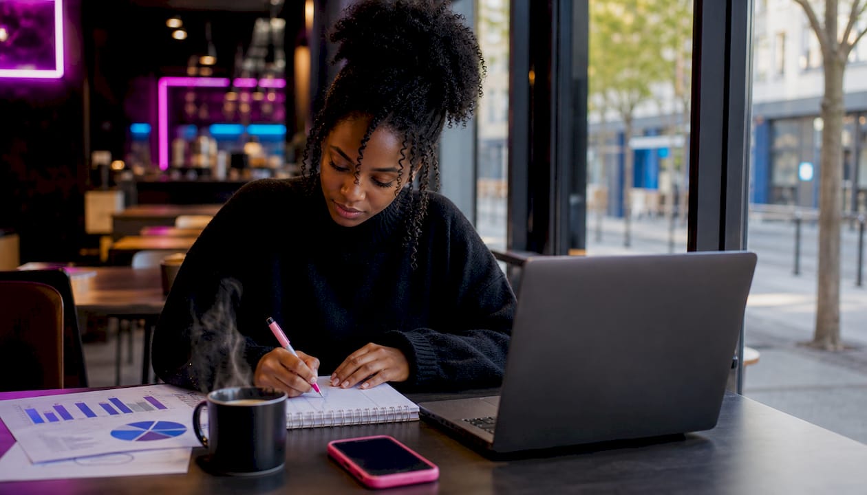 Des mains tapent sur un clavier, entourées de graphiques et de données marketing à l’écran.