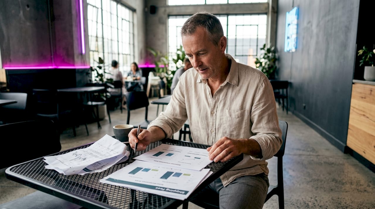 Des mains pianotent sur un ordinateur portable, affichant des graphiques sur les frais de livraison.