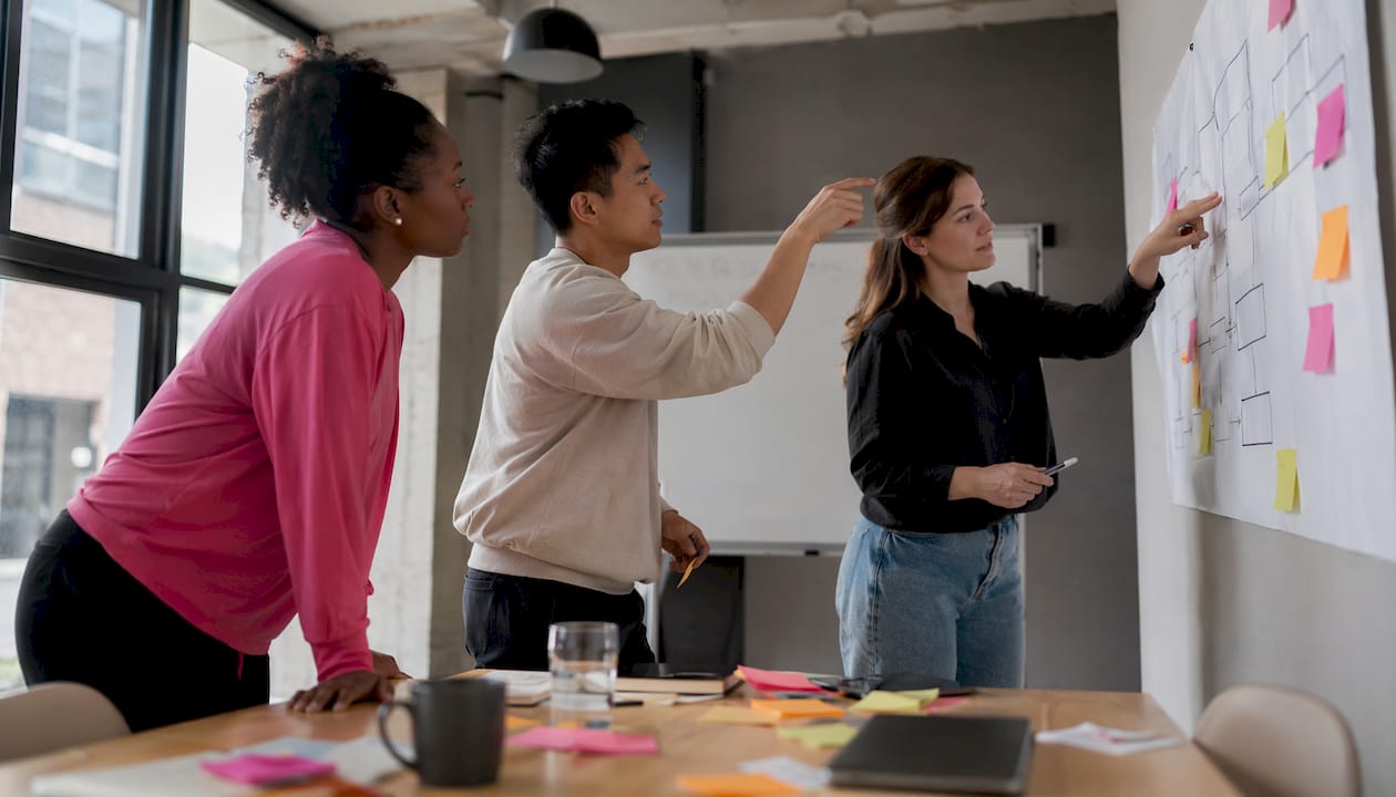 Lors d’une réunion, l’équipe passe en revue le schéma des processus afin d’optimiser l’organisation du travail.