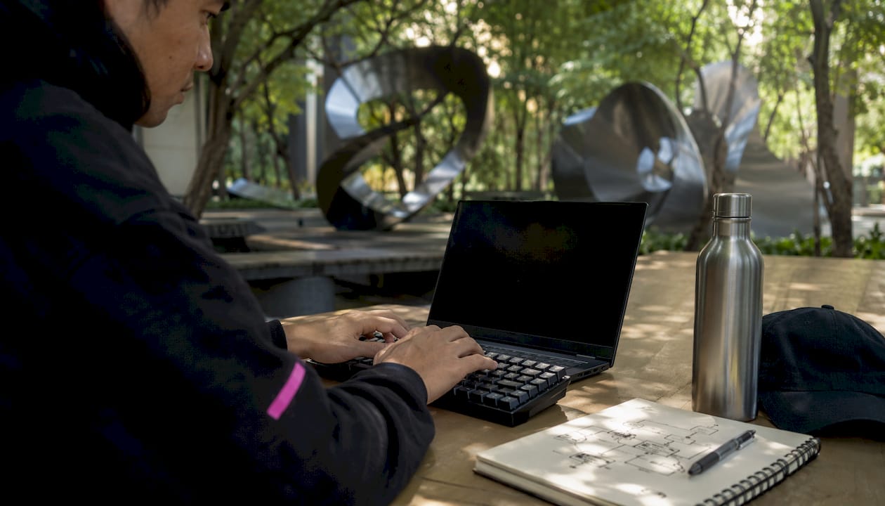 Des doigts qui s’activent sur un clavier au beau milieu de l’open space