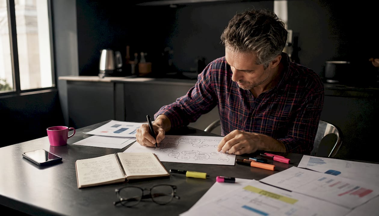 Des mains s'affairent à élaborer des documents de stratégie pour le référencement naturel.