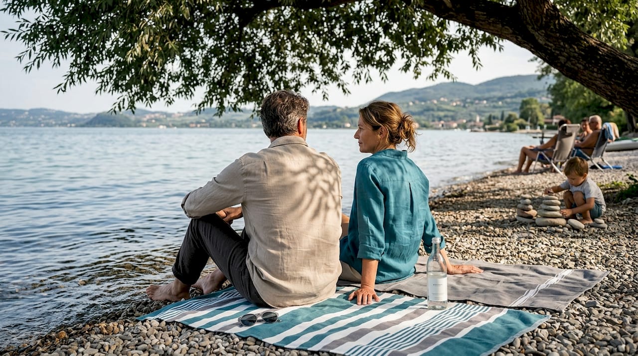 Due innamorati si godono un momento di relax sulla spiaggia del Lago di Garda.