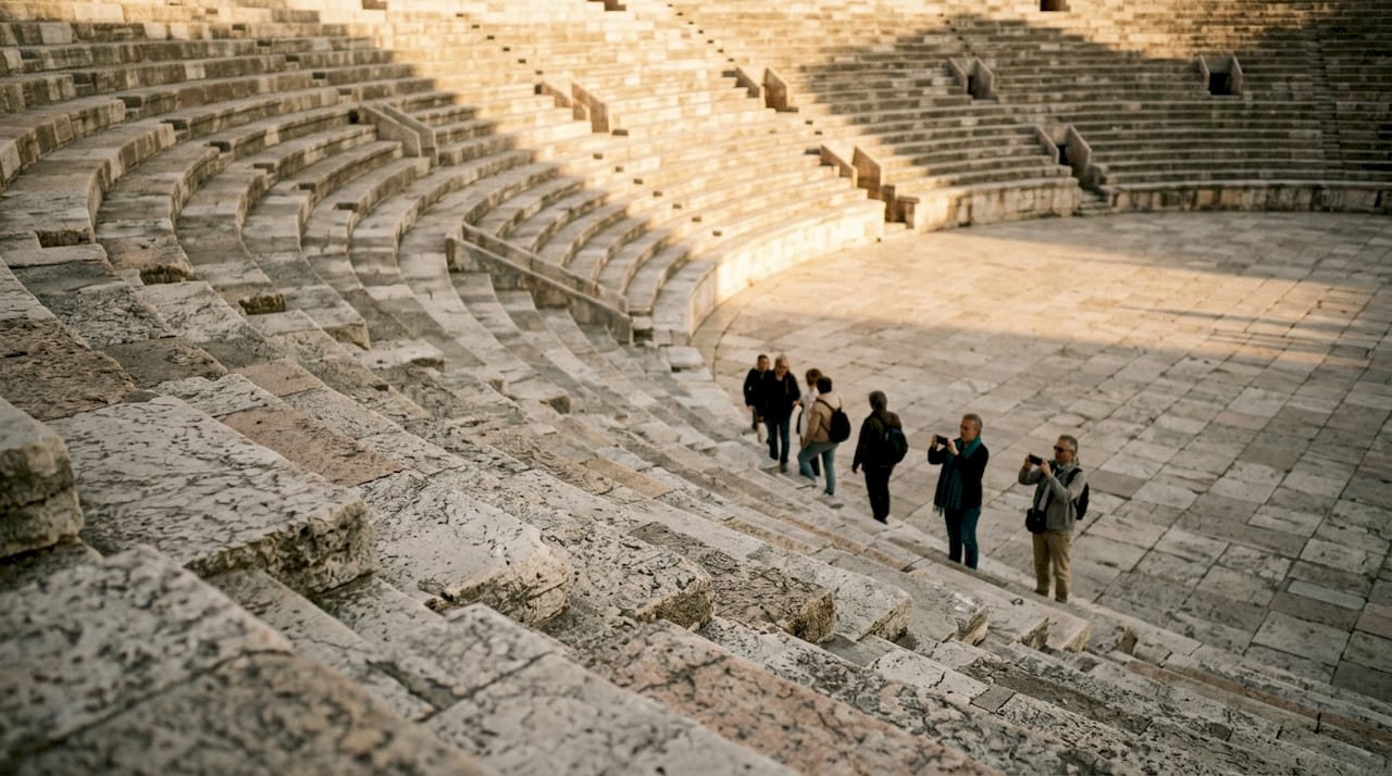Vista dell’interno dell’Arena con le gradinate e un gruppo di visitatori intenti a esplorare lo spazio