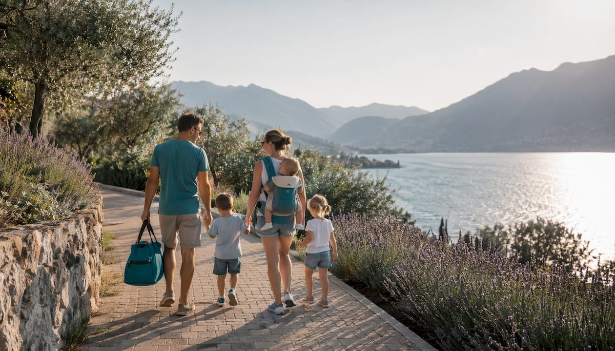 Una famiglia passeggia tranquillamente lungo le rive del Lago di Garda, immersa nella bellezza del paesaggio.
