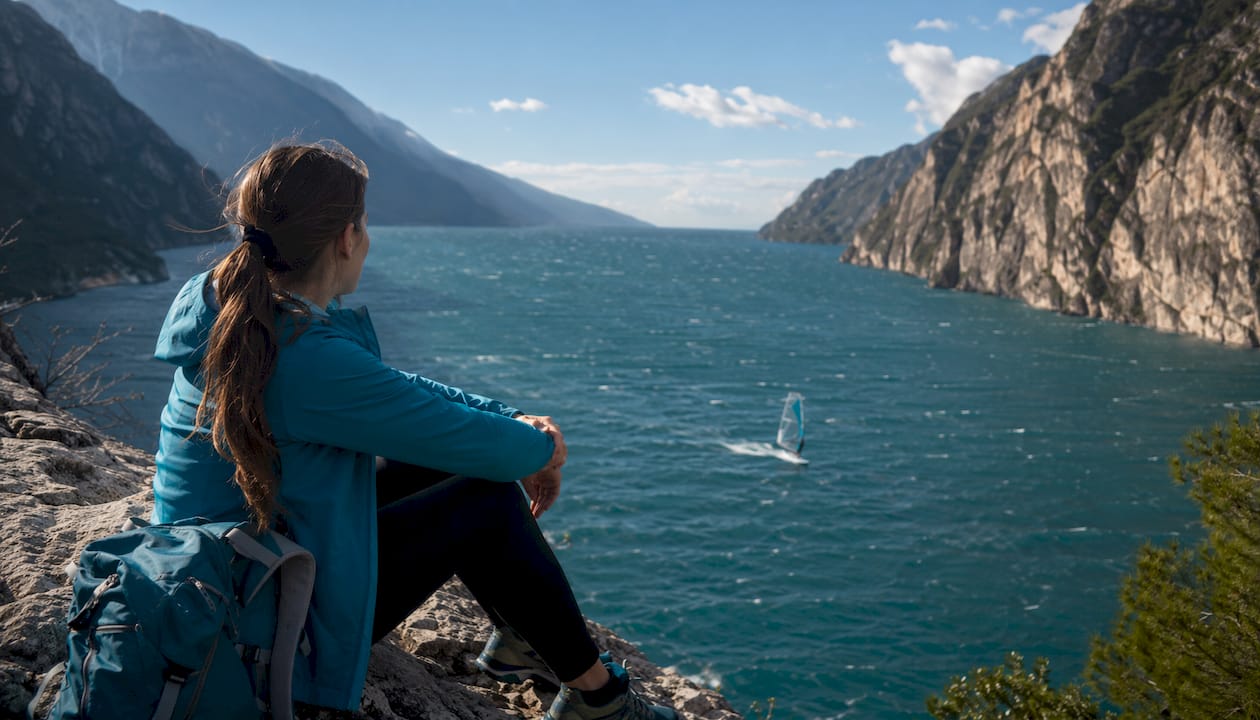 Vista panoramica sul lago che si restringe, con le tipiche onde create dai windsurf che si rincorrono sulla superficie.