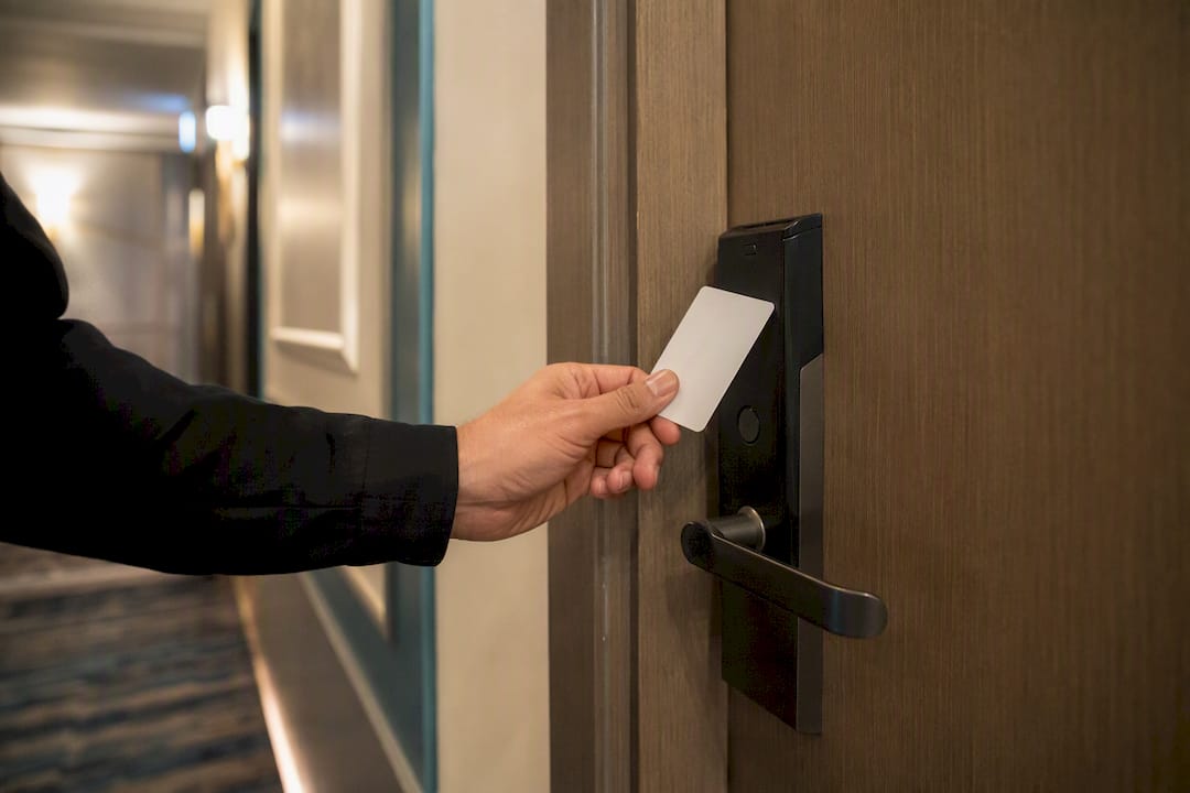 Mano che tiene la tessera per aprire la porta della camera d'hotel
