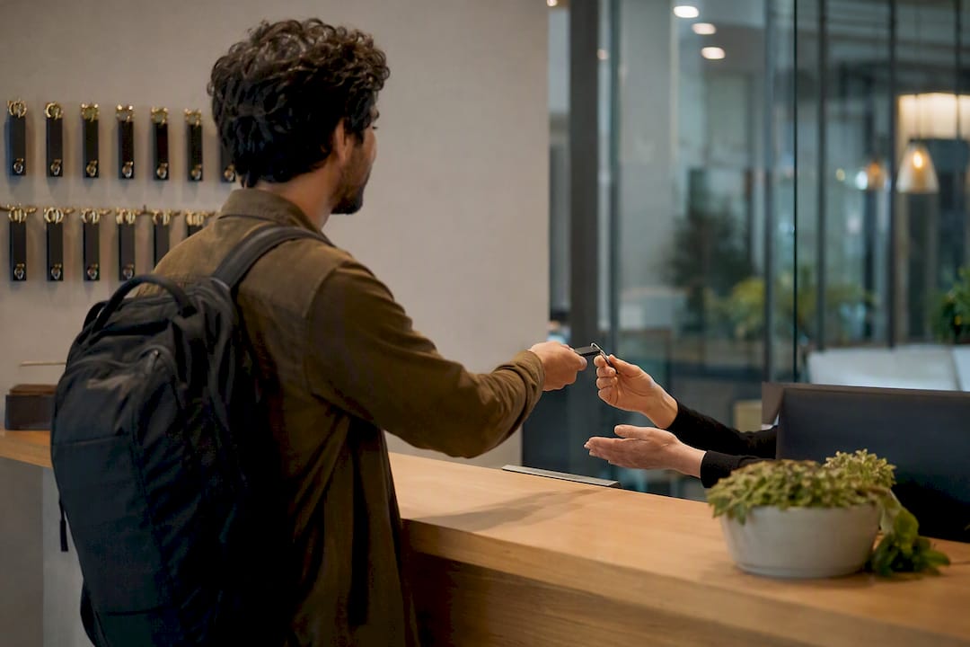 Ospite che consegna la chiave della camera alla reception dell'hotel