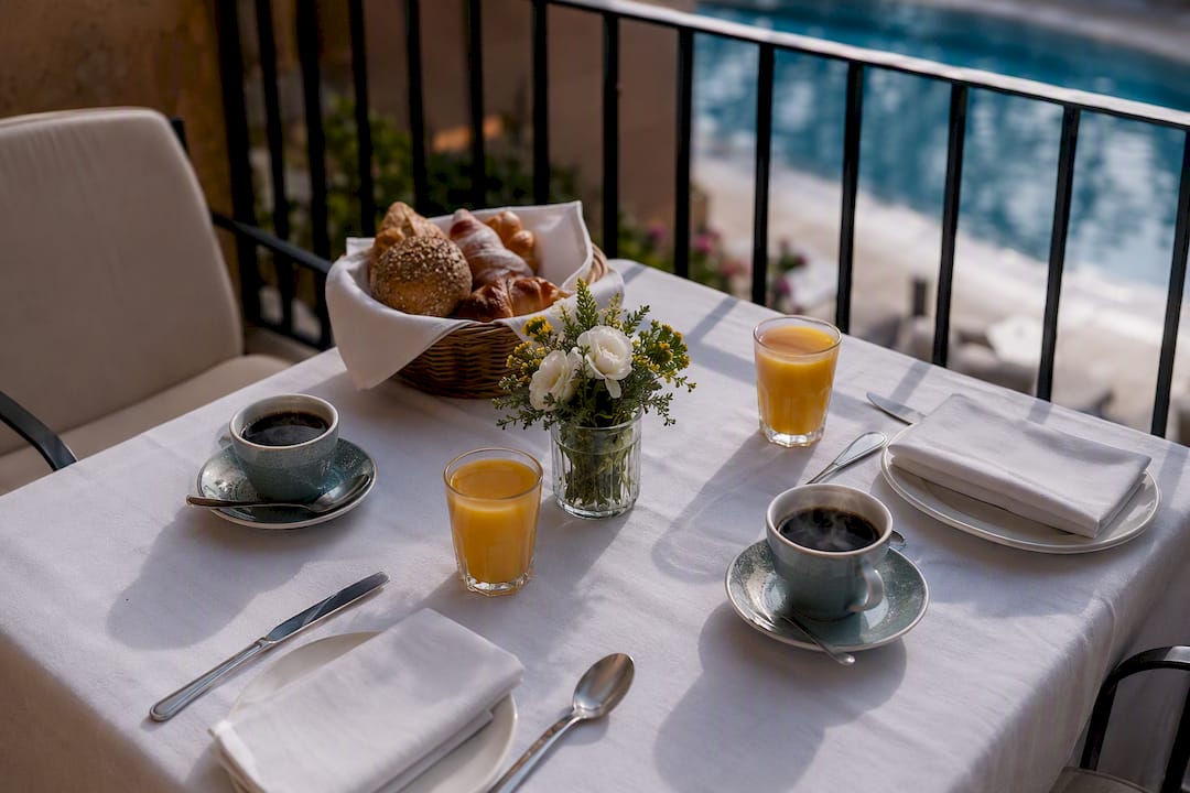 Tavola per la colazione con vista piscina sulla terrazza dell'hotel