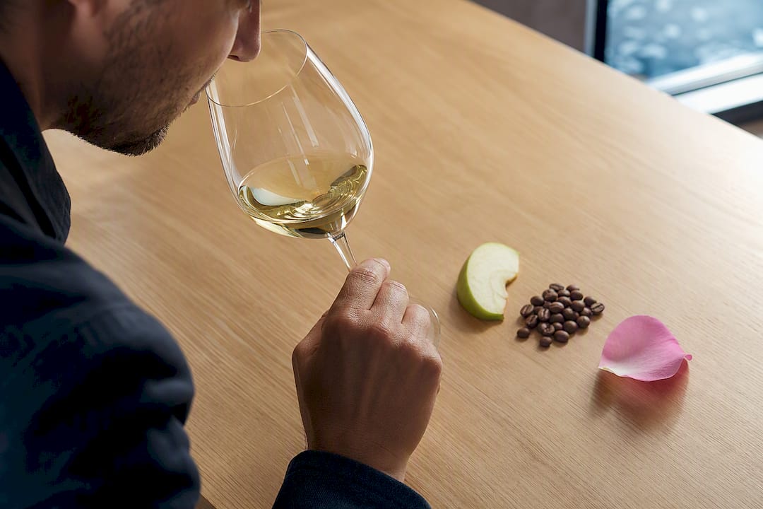 Calice di vino con mela, caffè e rosa