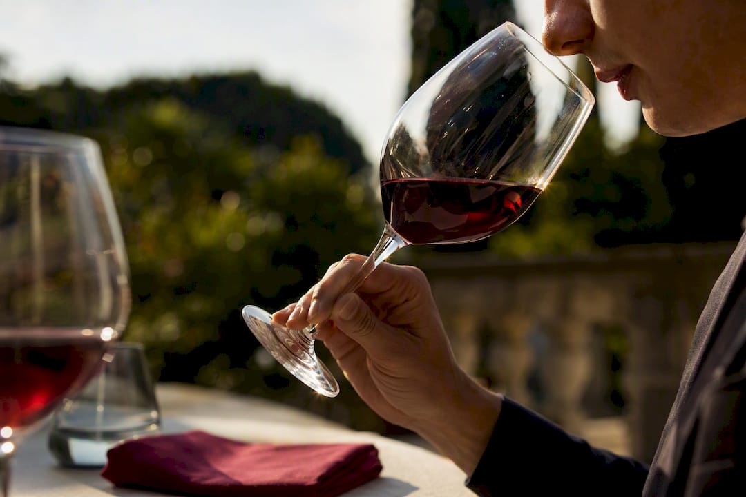 Un degustatore osserva e fa roteare un calice di vino