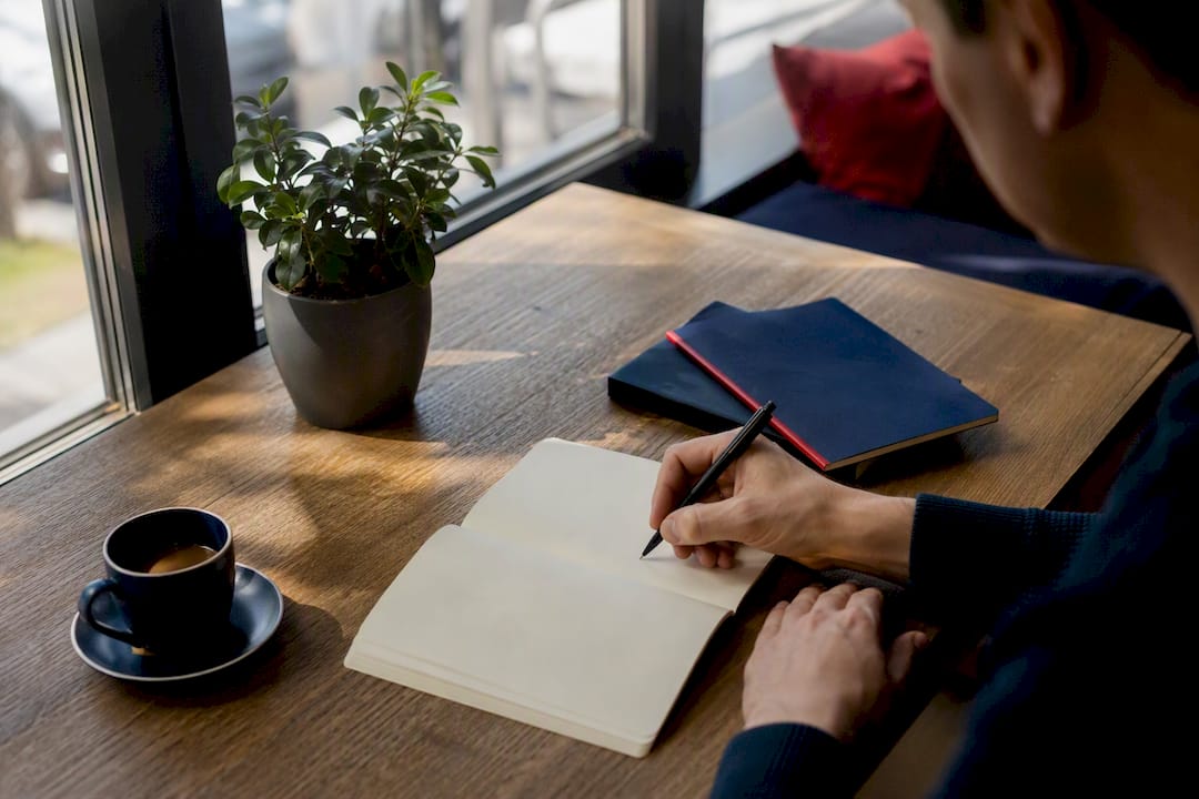 Pen poised over notebook for SEO content planning