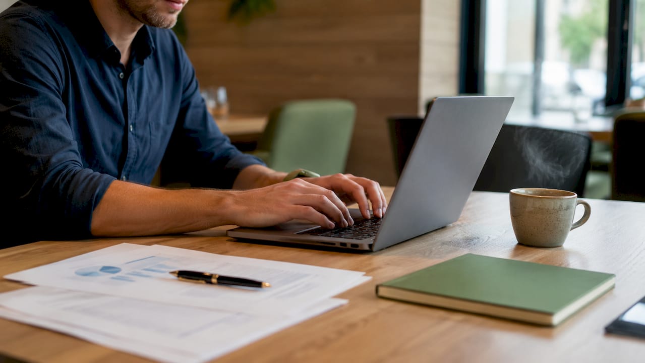 Dita che scorrono sulla tastiera mentre si sceglie il software giusto per la gestione dei documenti