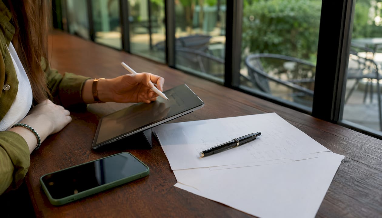 Primo piano di mani che scrivono inviti su un tablet