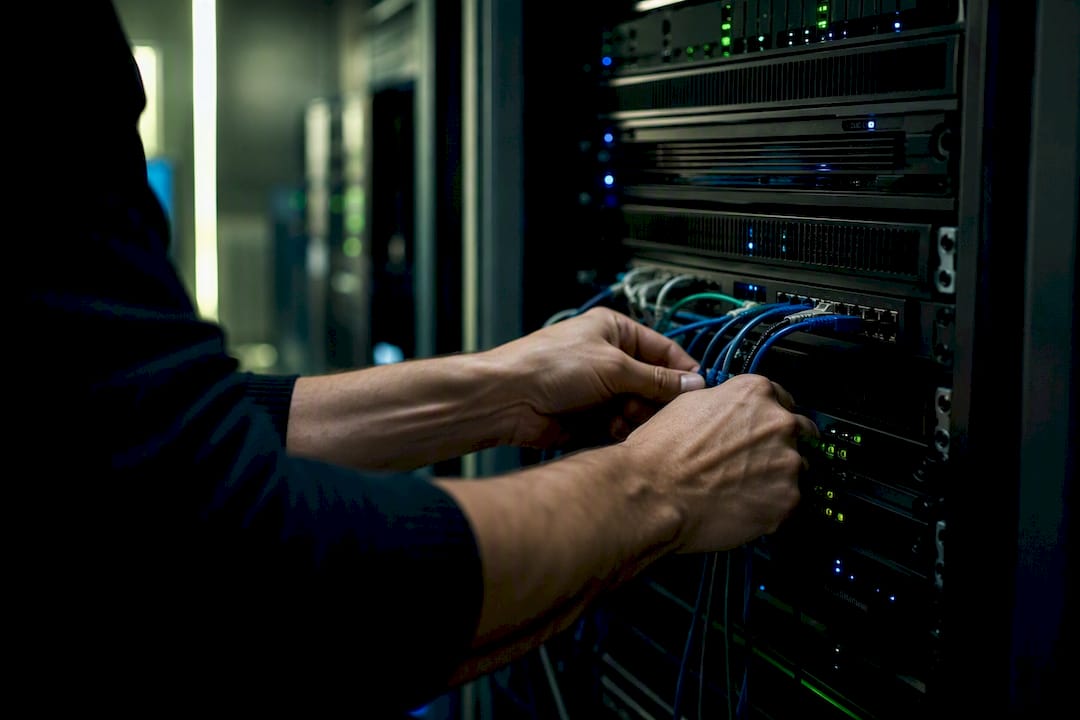Mani che collegano i cavi per sincronizzare l'inventario sul server di un negozio