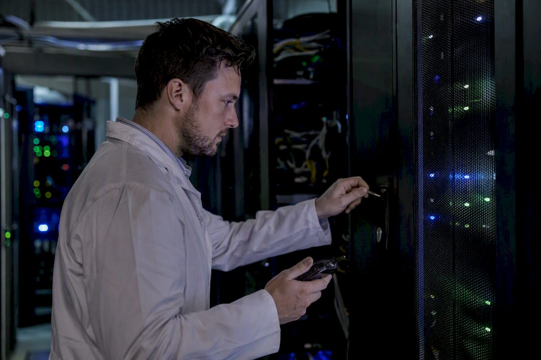 Un tecnico esamina attentamente le apparecchiature dedicate alla sicurezza informatica, controllando ogni dettaglio per garantirne il corretto funzionamento.