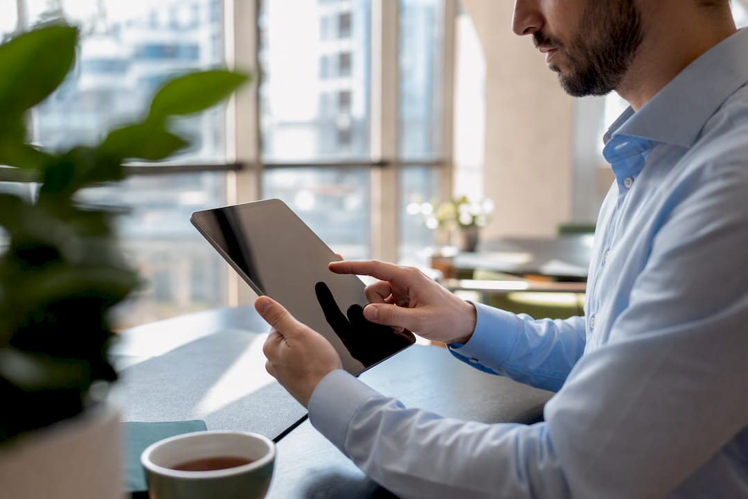 Mani che tengono un tablet con grafici per misurare il ROI