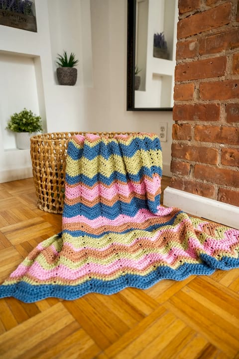 Woman crocheting ripple chevron blanket colorful