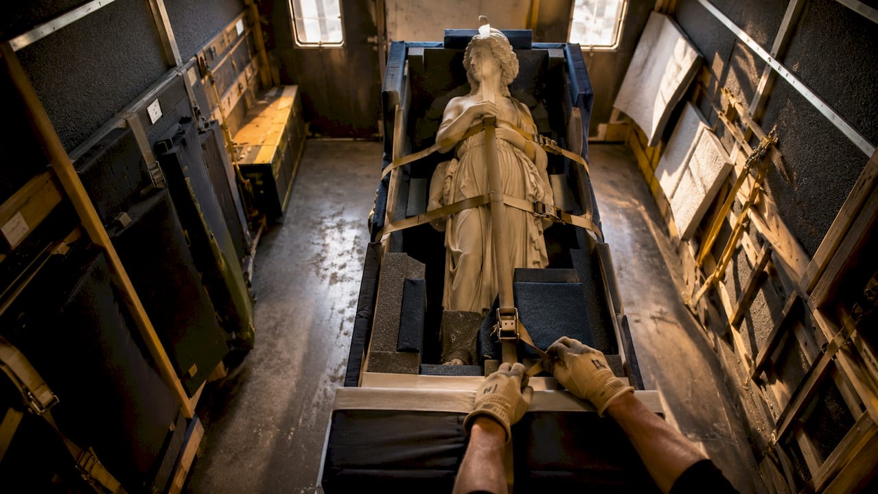Hands securing straps inside climate-controlled transport truck