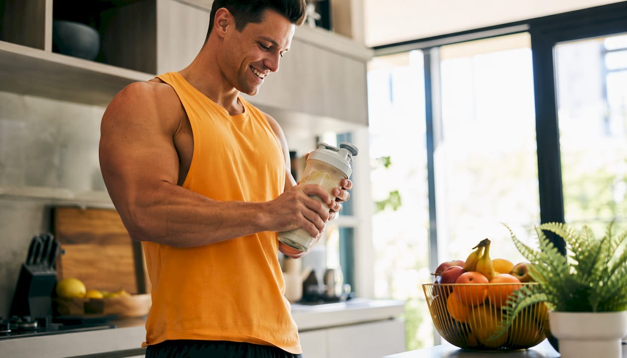 Close-up of hands mixing BCAA protein shake at home kitchen